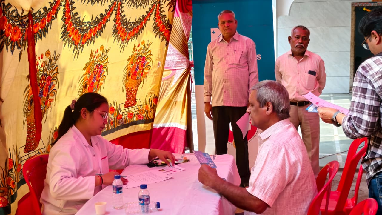 Health camp registration desk with volunteers assisting visitors